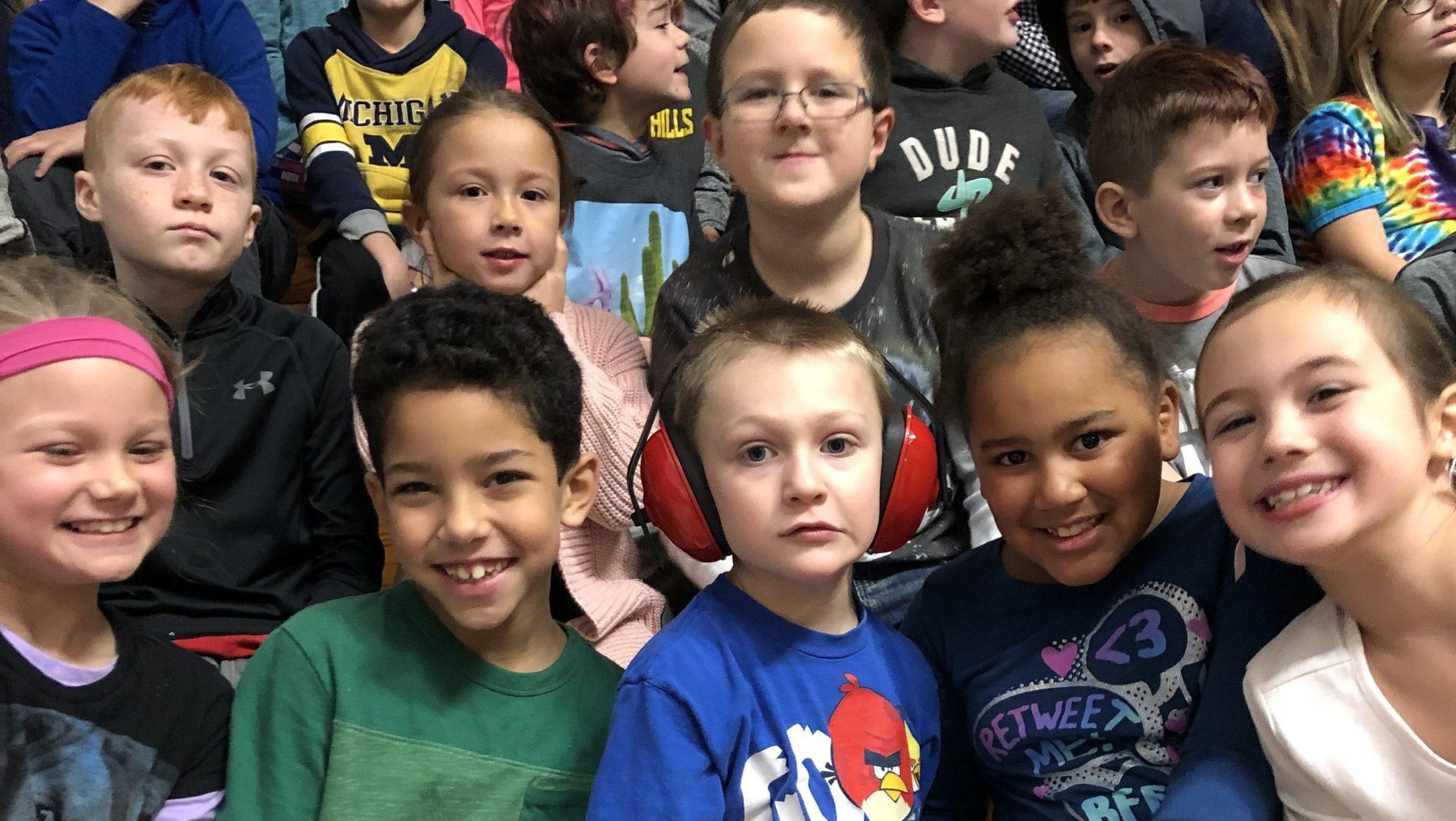 Jackson and his classmates in the bleachers at a school assembly.