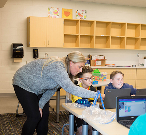 KHPS Central Feature4 060223 teacher leans in to help a student