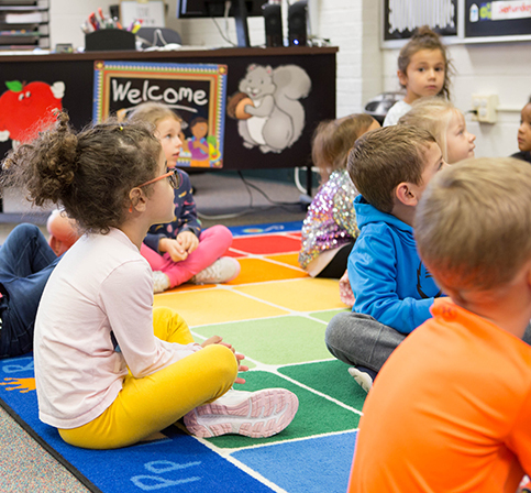 KHPS Zinser Feature1 060223 students sitting on floor listening